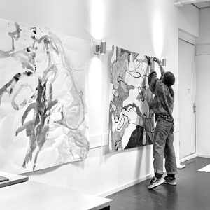 Maker van kunst hangt haar grote tekeningen aan de muur